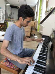 Eshan Goodarzi spielt auf dem Klavier im Familienzentrum